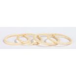 Pair of ivory bangles with twist carved decoration, two ivory bangles of plain form (4)