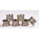 Collection of Chinese white metal napkin rings, decorated in various styles with dragons, bamboo,