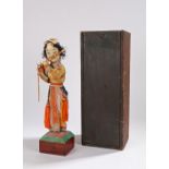 Chinese Republic figure of a boy playing a flute, richly dressed in silk with tassels and beads,