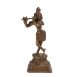 20th Century Indian brass figure of Krishna one leg across the other and playing a flute and on
