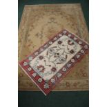 Two rugs, the first with a cream field and foliate decoration, the second with flower decoration, (