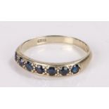 9 carat white gold and sapphire set ring, with a row of seven sapphires to the head, ring size O