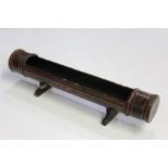 Black lacquered pen tray, formed from a section of bamboo, with red scroll decoration, 30cm wide