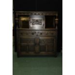 17th Century style oak court cupboard, with a lunette carved frieze above a floral panelled cupboard