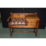 Oak telephone table with two drawers and brown leather effect button seat, raised on turned legs and