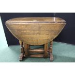 Oak drop leaf occasional table, with D shaped leaves, on turned legs and flattened stretchers,