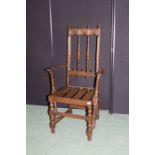 Ercol elbow chair, with arch carved back, on turned legs and flattened stretchers