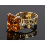 18 carat gold citrine and diamond set ring, the emerald cut orange citrine with four diamonds to