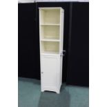 White bathroom cabinet, with open shelves above a cupboard door, with chrome towel rail to the right