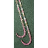 Two twisted clear glass walking sticks with coloured bead decorated interiors (2)