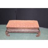 Chinese style footstool, with upholstered hinged seat, on scrolled floral carved legs, 70cm wide
