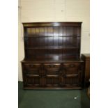 18th Century style oak dresser, with plate rack top above three frieze drawers and three panelled