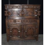 17th Century style oak court cupboard, with a fruiting vine carved frieze above two arched