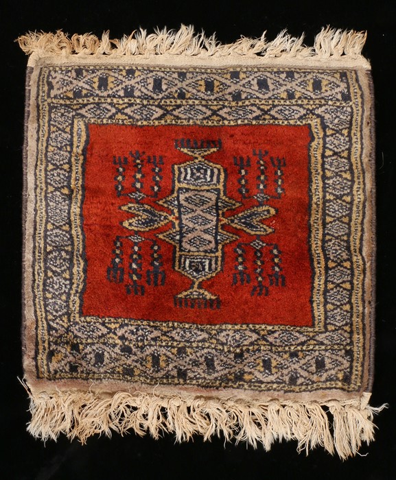 Miniature Persian rug, with a red ground and central medallion, 32cm x 30cm