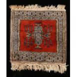 Miniature Persian rug, with a red ground and central medallion, 32cm x 30cm