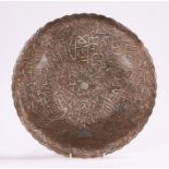 Late 19th Century Islamic silver inlaid dish with reticulated rim, punched copper with trailing