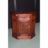 Old Charm oak cupboard, with frieze drawer above a foliate and scroll carved panel door, flanked