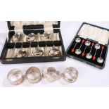 Two silver napkin rings, cased set of six plated coffee spoons with red coffee bean form finials,