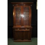 Edwardian mahogany bookcase, the down swept pediment above two glazed doors opening to reveal