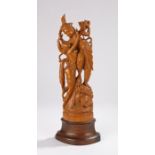 Balinese carved figural group, with two figures standing on a plinth base with gushing water from