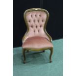 Victorian style nursing chair, the spoon form back with buttoned upholstery and serpentine front