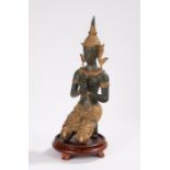 Thai bronze figure depicting a kneeling deity wearing an elaborate gilt headdress, on a non-