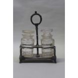 Silver plated stand, containing two cut glass bottles with a carrying handle and foliate silver
