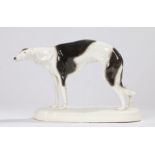Goldscheider porcelain greyhound, modelled in a standing position, on an oval white plinth base,