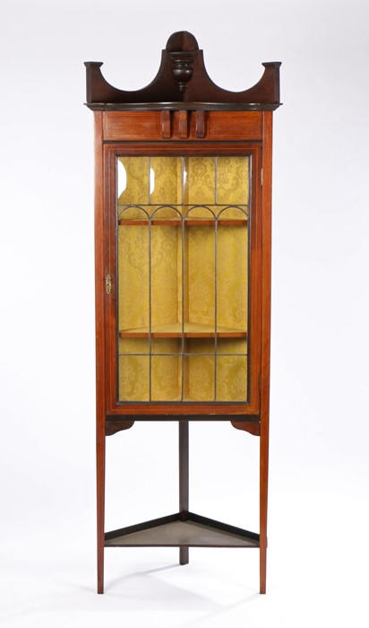 Edwardian mahogany and boxwood strung standing corner cupboard, with down swept pediment above a