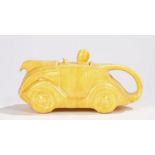 Sadler Art Deco ceramic novelty teapot modelled as a racing car and driver in mottled yellow, 22cm