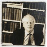 Black and white photograph depicting Boris Johnson in front of a bookcase signed indistinctly to the