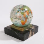 1930's tin moneybox in the form of the globe, raised on an onyx and black marble base, 9.5cm high
