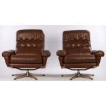Pair of 1970's brown leather upholstered swivel arm chairs, with button backs, armrests and seats,