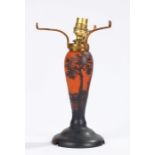 Art Nouveau lamp in the style of Galle, the orange body with overlaid black landscape decoration,