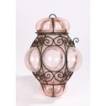 Arts and Crafts style lantern, the scrolled wrought iron frame housing the bulbous amethyst glass