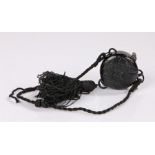 1920s black Bakelite powder compact with a cord handle and decorative tassel with a lipstick