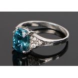 Zircon and diamond set ring, with a central 5.67 carat blue zircon and three diamonds to either