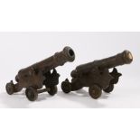 Pair of early 20th Century bronze cannons, with tapering barrels raised on the carriages, the cannon