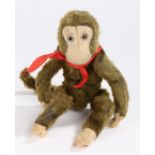 Farnell's Alpha Toys green plush covered monkey, with red scarf and label to the back leg