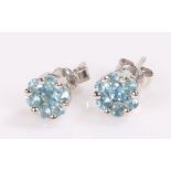 Pair of 9 carat white gold earrings, with blue stone flower head design heads