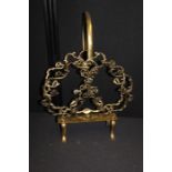 Brass Canterbury, with loop handle above the pierced rococo scroll decorated body, on scroll feet,