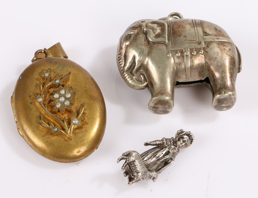 Silver plated novelty rattle, as an elephant, together with a pendant and locket, (3)