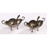 Pair of silver mustards, with arched handles and shaped bowls