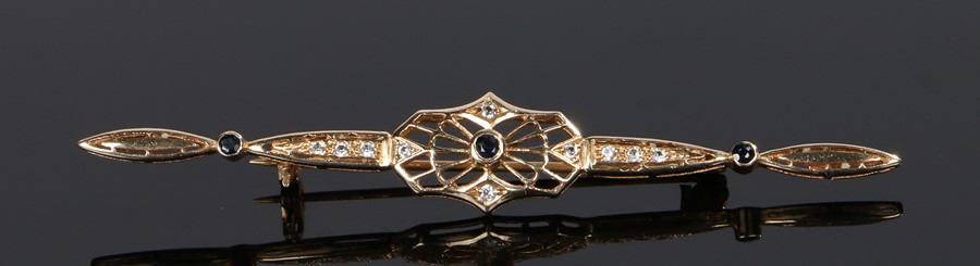 14 carat gold sapphire set brooch, the long bar set with three round cut sapphires and cubic