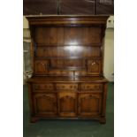 Georgian style oak dresser, he down swept pediment above two shelves, two arched panelled cupboard