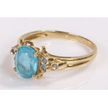 9 carat gold ring, with a central blue stone and clear stones to the sides, ring size T