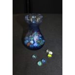 Collection of glass marbles held in a blue glass vase, (Qty)