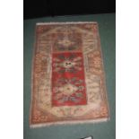 Middle Eastern carpet, the brick red ground surrounded by foliate borders, 79cm x 119cm