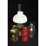 Brass oil lamp with glass chimney and shade together with two smaller oil/storm lamps and a candle