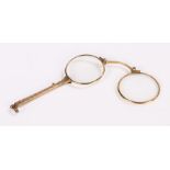 Pair of gilt metal lorgnettes, with scroll engraved handle and sprung mechanism